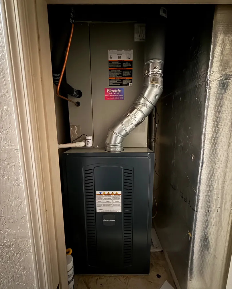 New furnace with an Elevate sticker, installed in a home's utility closet