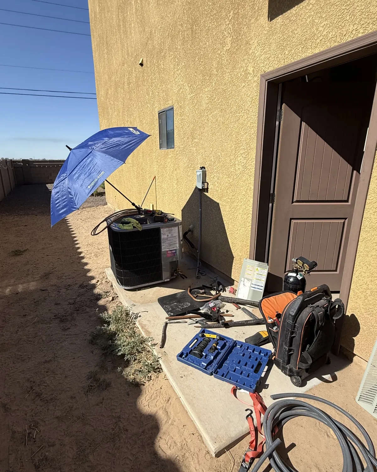 Tools laid out beside an outdoor AC unit during an Elevate service visit