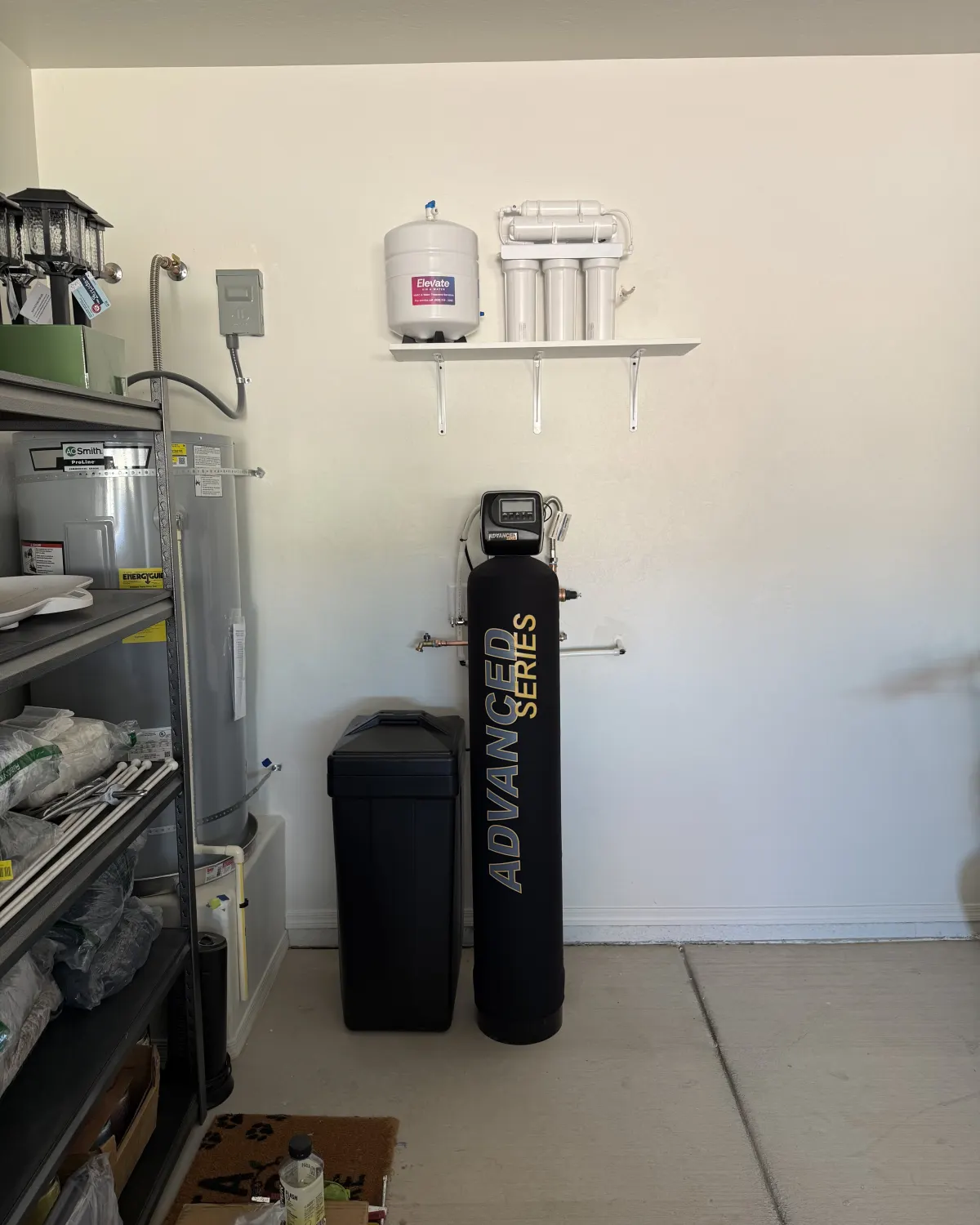 Wall-mounted RO filters and a water softener installed by Elevate